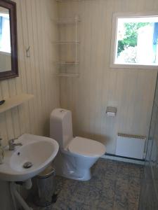 a bathroom with a white toilet and a sink at Lodge åstön in Söråker