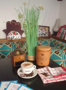 a table with a cup of coffee and a vase at The Exiles Hotel in Sliema