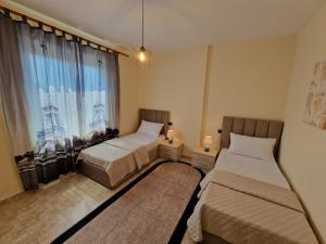 een slaapkamer met 2 bedden en een raam bij Donel Apartment in Durrës