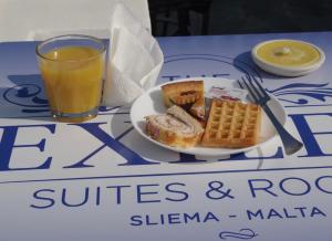 a plate of toast and waffles and a glass of orange juice at The Exiles Hotel in Sliema