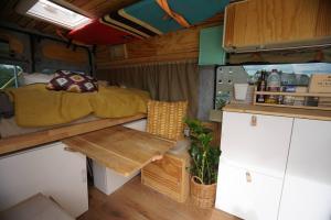 1 dormitorio con 1 cama y 1 mesa en una cabaña en Transi the Van, en Düsseldorf