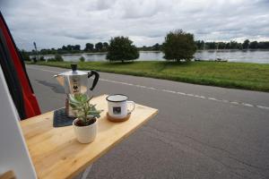 una mesa con cafetera y una taza de café. en Transi the Van, en Düsseldorf