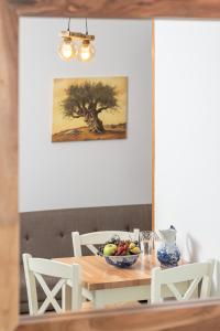 una mesa de comedor con un bol de fruta. en Lemon Tree Apartments Samos, en Votsalákia