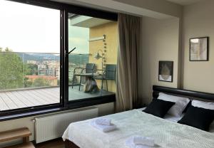 a bedroom with a bed and a large window at Tarnovo Studios City Center in Veliko Tŭrnovo +54 photos