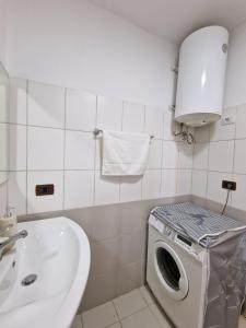 een badkamer met een wasmachine en een wastafel bij Donel Apartment in Durrës