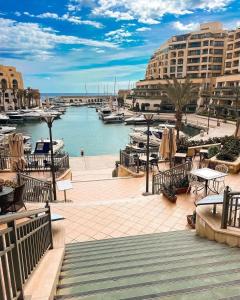 a marina with tables and boats in the water at The Exiles Hotel in Sliema