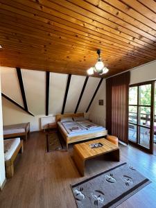a room with two beds and a wooden ceiling at Prenoćište/Restoran Lovac in Bihać