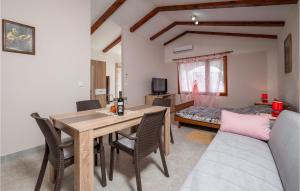ein Wohnzimmer mit einem Tisch und Stühlen sowie ein Schlafzimmer in der Unterkunft 2 Bedroom Gorgeous Home In Valtura in Valtura