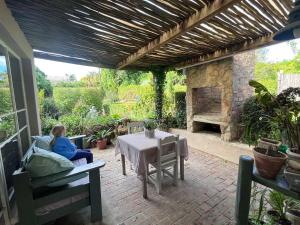 Eine Frau, die an einem Tisch auf einer Terrasse sitzt in der Unterkunft 35 on Basil in Caledon