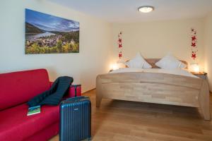 巴哈拉赫的住宿－艾康尼歇霍夫酒店，一间卧室配有一张床和一张红色的沙发
