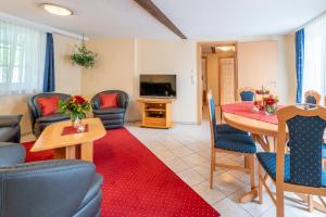 a living room with a table and chairs and a television at Altkölnischer Hof in Bacharach