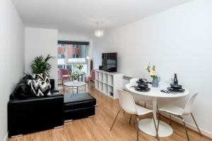 a living room with a table and a couch at Central Gunwharf Quays Two Bedroom apartment in Portsmouth