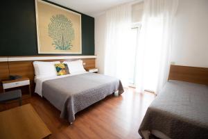 a hotel room with two beds and a table at Hotel Crystal in Caorle