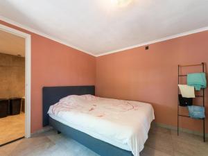 1 dormitorio con 1 cama en una habitación con paredes de color naranja en Comfortable house with a large garden and parking in the Achterhoek, en Eibergen