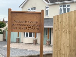 a sign in front of a house at Wassells House Accommodation in Cheddar