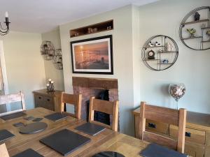a dining room with a table and a fireplace at Wassells House Accommodation in Cheddar