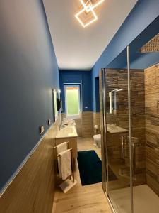 baño azul con ducha y lavamanos en Vista Eolie Milazzo- Apartments, en Milazzo