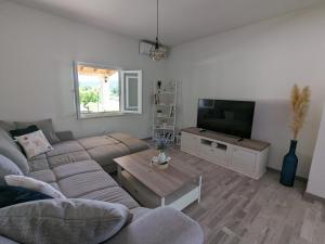 a living room with a couch and a tv at Runaway Cottage in Unešić