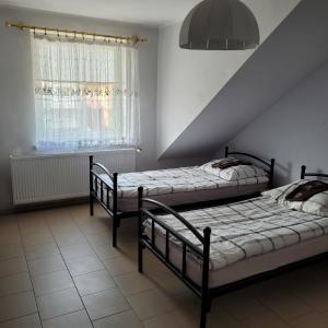 1 dormitorio con 2 camas y ventana en Noclegi Starogard, en Starogard Gdański
