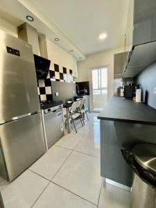 a kitchen with a stainless steel refrigerator and a table at appartement paisible face au stade velodrome in Marseille