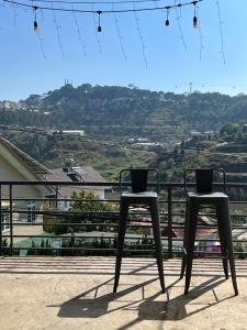 two black stools on a balcony with a view at Crush Va Toi in Da Lat