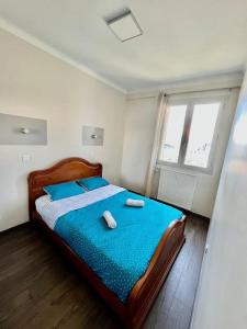 a bedroom with a bed with blue sheets and blue pillows at appartement paisible face au stade velodrome in Marseille