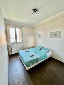 a bedroom with a bed and a ceiling fan at appartement paisible face au stade velodrome in Marseille