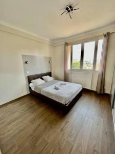 a bedroom with a large bed and wooden floors at appartement paisible face au stade velodrome in Marseille