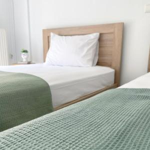 2 camas con sábanas verdes y blancas en un dormitorio en Down town villa Kavala en Kavala