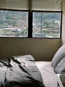 an unmade bed in a bedroom with a window at Crush Va Toi in Da Lat