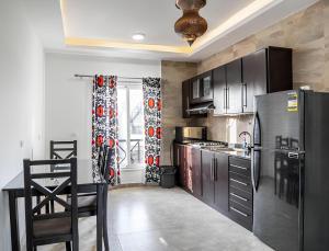 a kitchen with black appliances and a table and chairs at Royal Home Luxor Nile View in Luxor