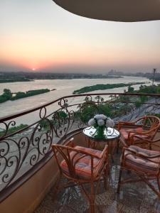 a balcony with chairs and a table with a view of a river at شقة على النيل بالمعادي in Cairo