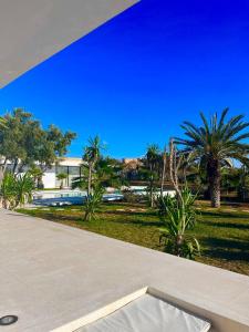 - une vue depuis le balcon d'une maison avec des palmiers dans l'établissement Villa Nausikaa Essaouira, Villa d'architecte luxe avec piscine, à Essaouira