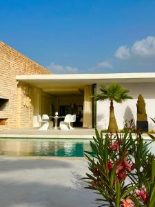 une maison avec une piscine en face d'une maison dans l'établissement Villa Nausikaa Essaouira, Villa d'architecte luxe avec piscine, à Essaouira