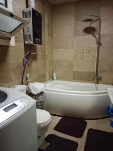 a bathroom with a tub and a toilet and a sink at شقة على النيل بالمعادي in Cairo