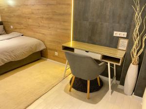 - une chambre avec un bureau et une chaise à côté d'un lit dans l'établissement Luxury Business Apartment in Centre of Chișinău, à Chişinău