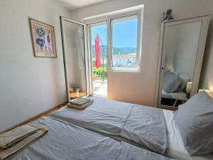 um quarto com uma cama e uma grande janela em Holiday House Oleas Stari Grad Hvar sunny terrace and 2 min to ocean and center em Stari Grad