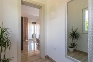 a mirror in a room with a hallway with plants at Amazing sea view apartment- Romantica in Kastel Stafilic