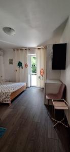 Schlafzimmer mit einem Bett und einem Flachbild-TV in der Unterkunft Apartments Villa Milenka in Novalja