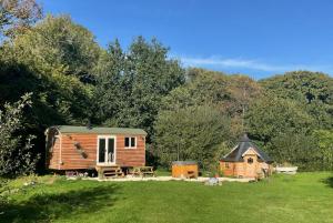 a small cabin in the middle of a field at Gillan Creek Retreat in Helston
