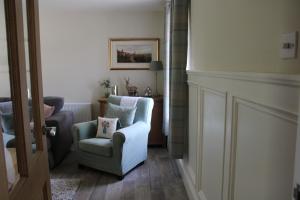 a living room with a white chair and a chair at Herds House Belcoo in Belcoo