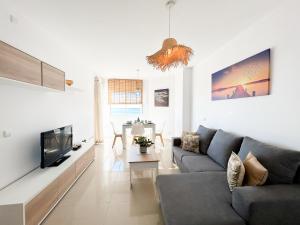 a living room with a couch and a tv at Apartment on the 1st line of the Sabinillas beach with sea views in San Luis de Sabinillas