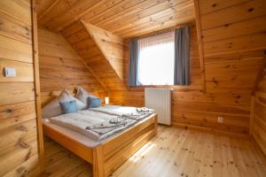 a bedroom of a log cabin with a bed and a window at u Marysi in Polanica-Zdrój
