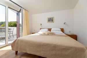 - une chambre avec un grand lit et un balcon dans l'établissement Apartments Maja, à Baška