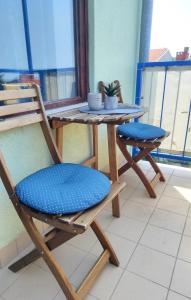 einen Tisch mit 2 Stühlen und einen Tisch mit einer Tasse in der Unterkunft Studio Vela in Izola