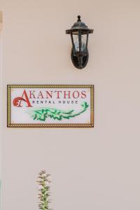 una señal para una casa de alquiler de kaminos colgada en una pared en AKANTHOS Rental House en Kórinthos