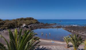 a group of people swimming in a pool on a beach at Apartamentos Charco del Conde in Valle Gran Rey
