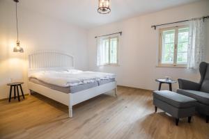 a bedroom with a bed and a couch and a chair at Apartmány Pernek in Horní Planá