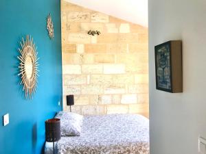 a bedroom with a bed and a brick wall at Logis des vignes in Saint-Émilion