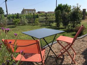 a table and two chairs sitting in a yard at Logis des vignes in Saint-Émilion